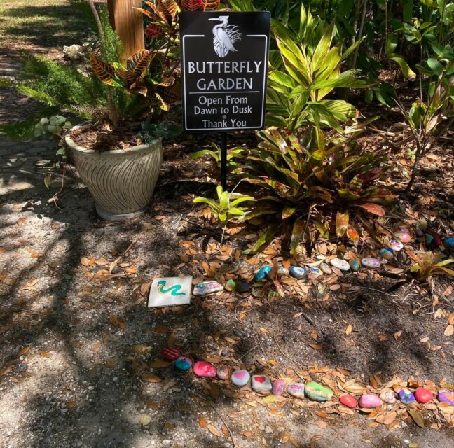 Butterfly Garden sign and painted rocks in the Herons Glen butterfly garden