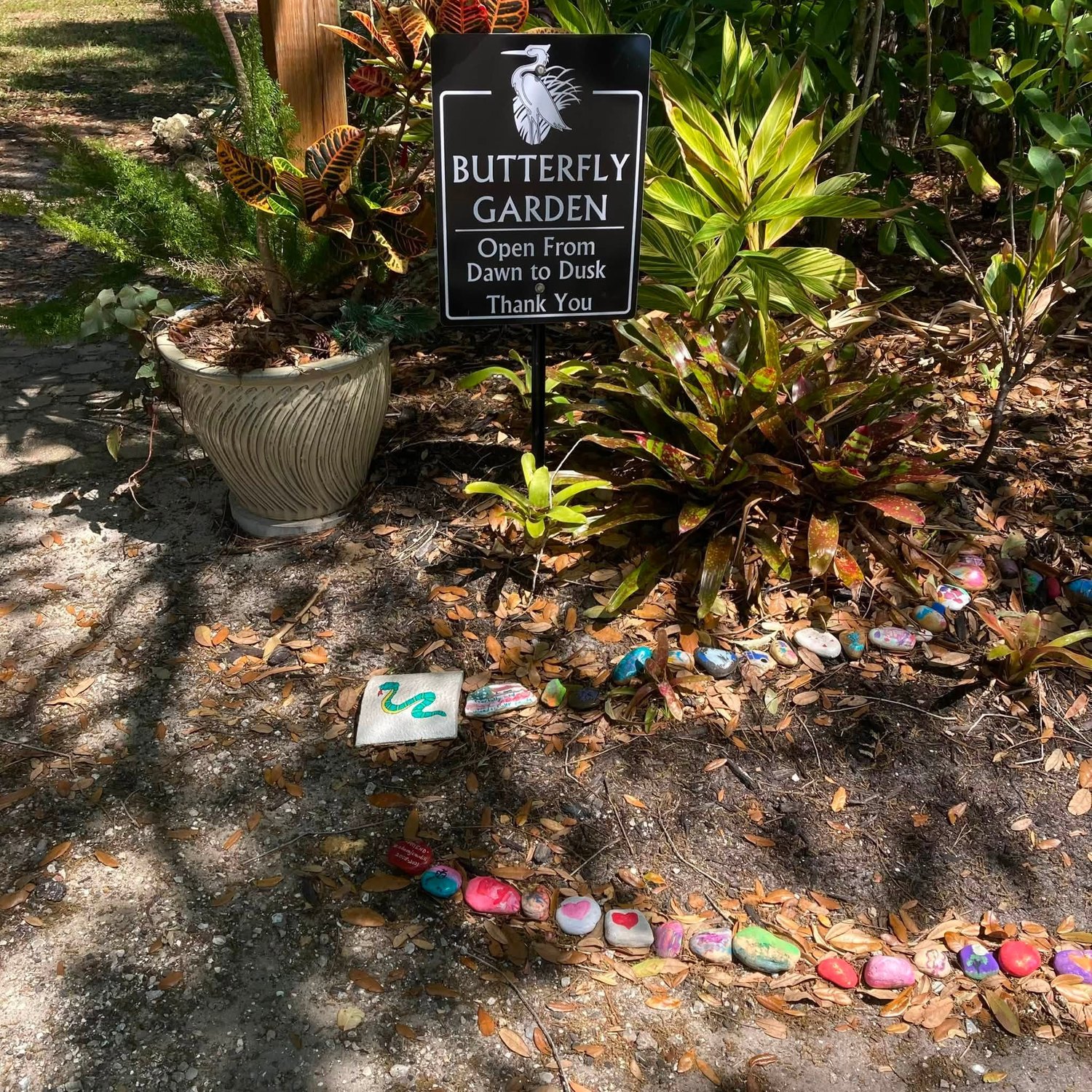 Butterfly Garden sign and painted rocks in the Herons Glen butterfly garden
