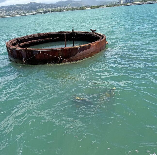 Rusted hull of the USS Arizona above the water at Pearl Harbor