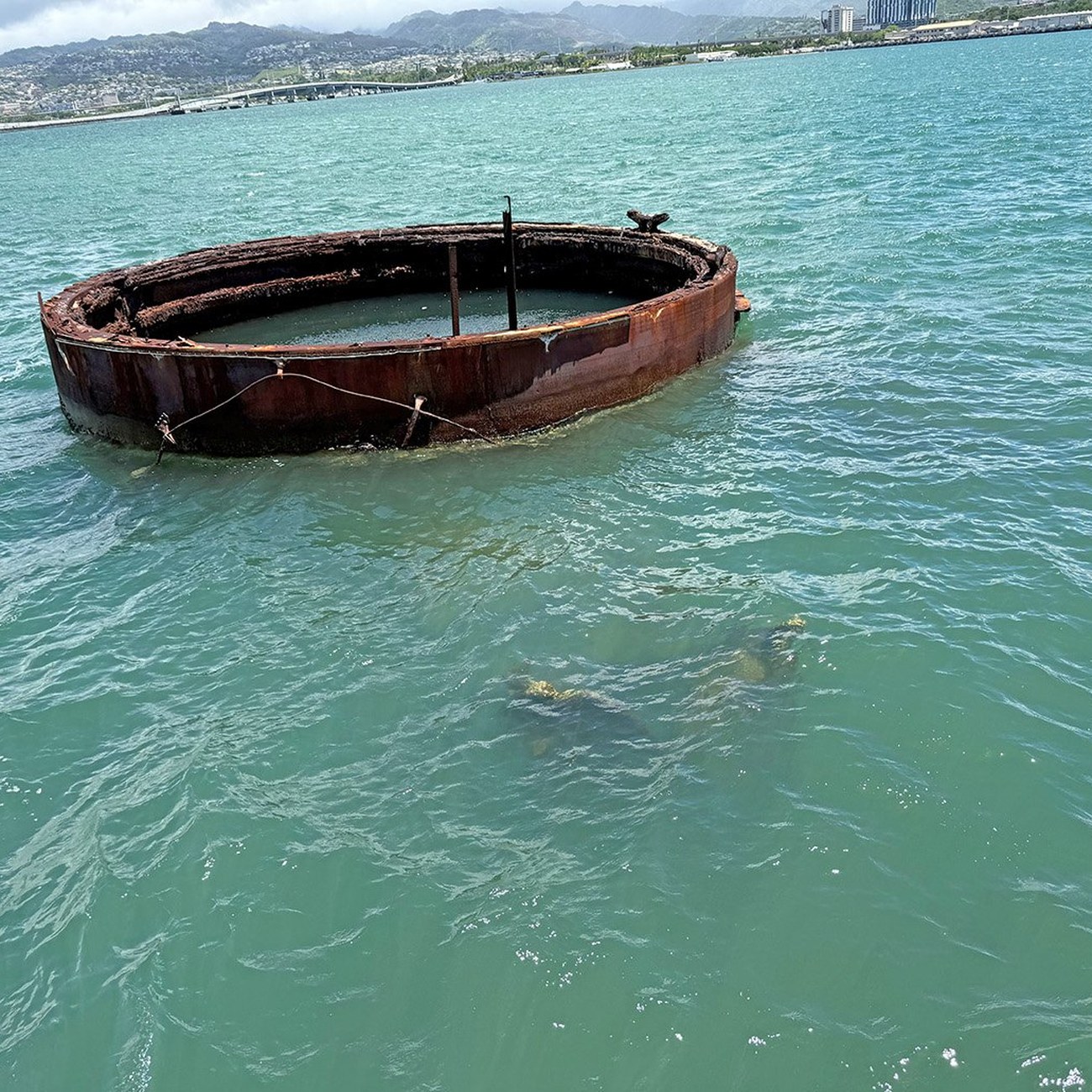 Rusted hull of the USS Arizona above the water at Pearl Harbor